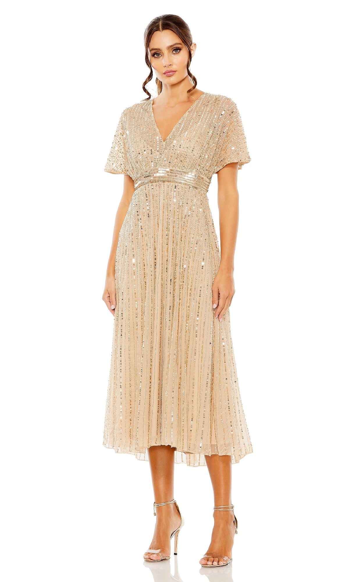 Model wears the Mac Duggal 14007, a knee-length gold sequin wedding-guest dress with short sleeves and v-neckline, styled with metallic high heels—ideal for semi-formal occasions. Shown against a white background.